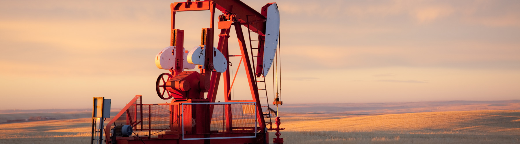 Red Prairie pump jack in oil field