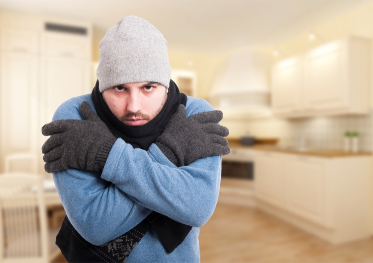 man shivering in house