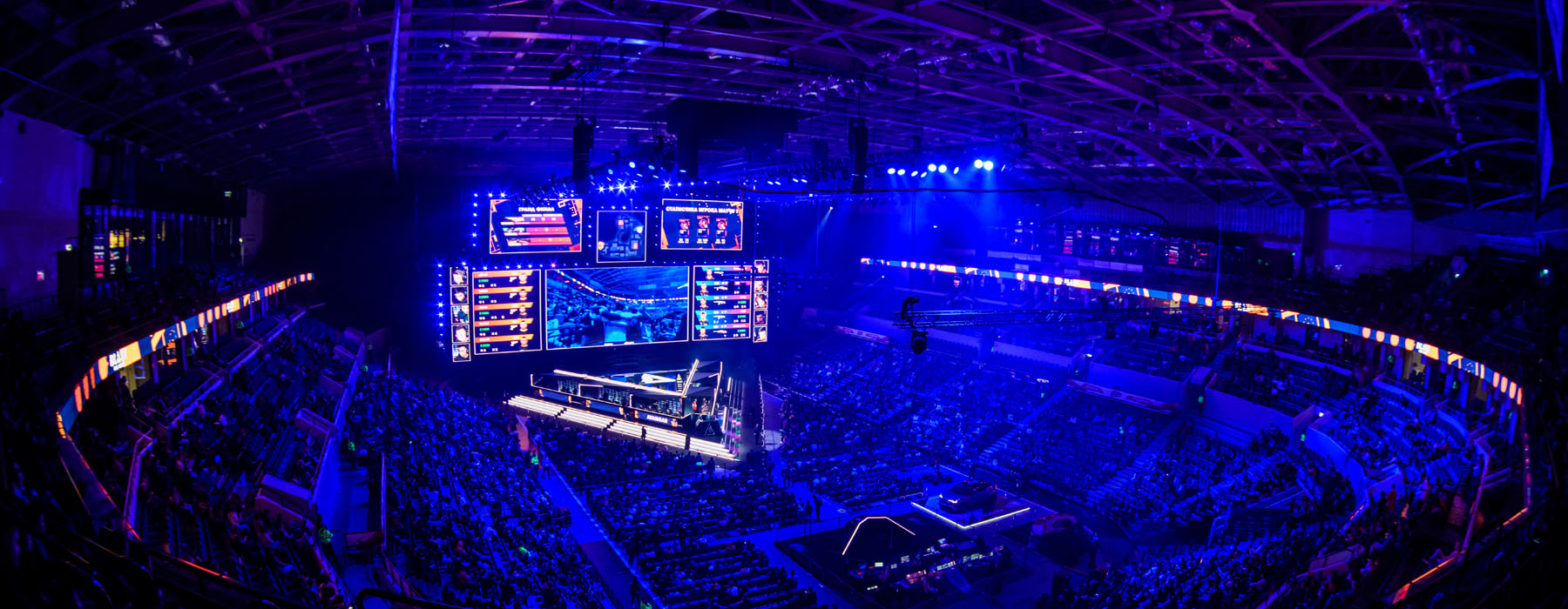 Dark arena full of people watching e-sports