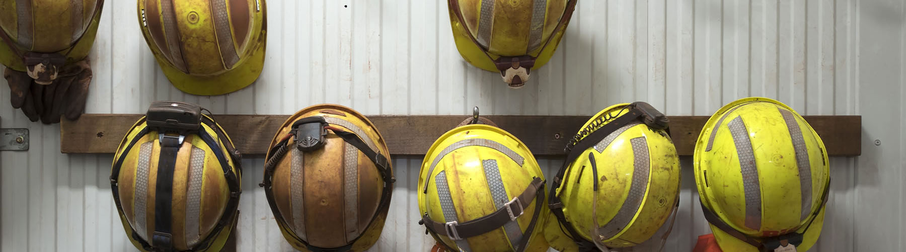 Safety helmets and gloves hang from a rack